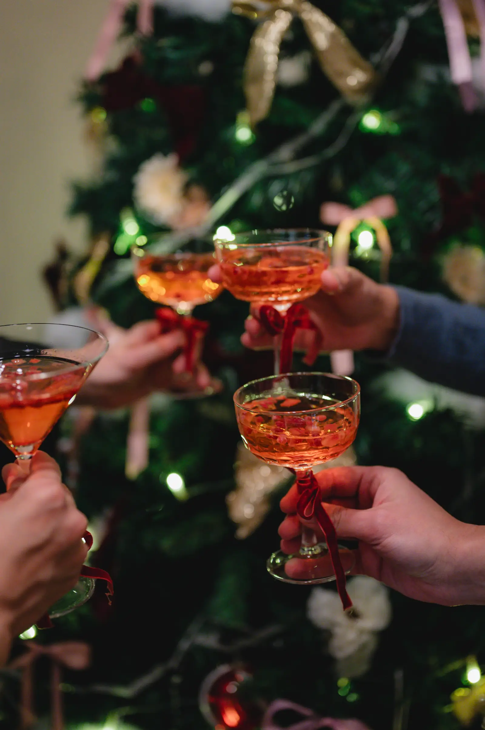 Guests clinking coupe glasses at a holiday party