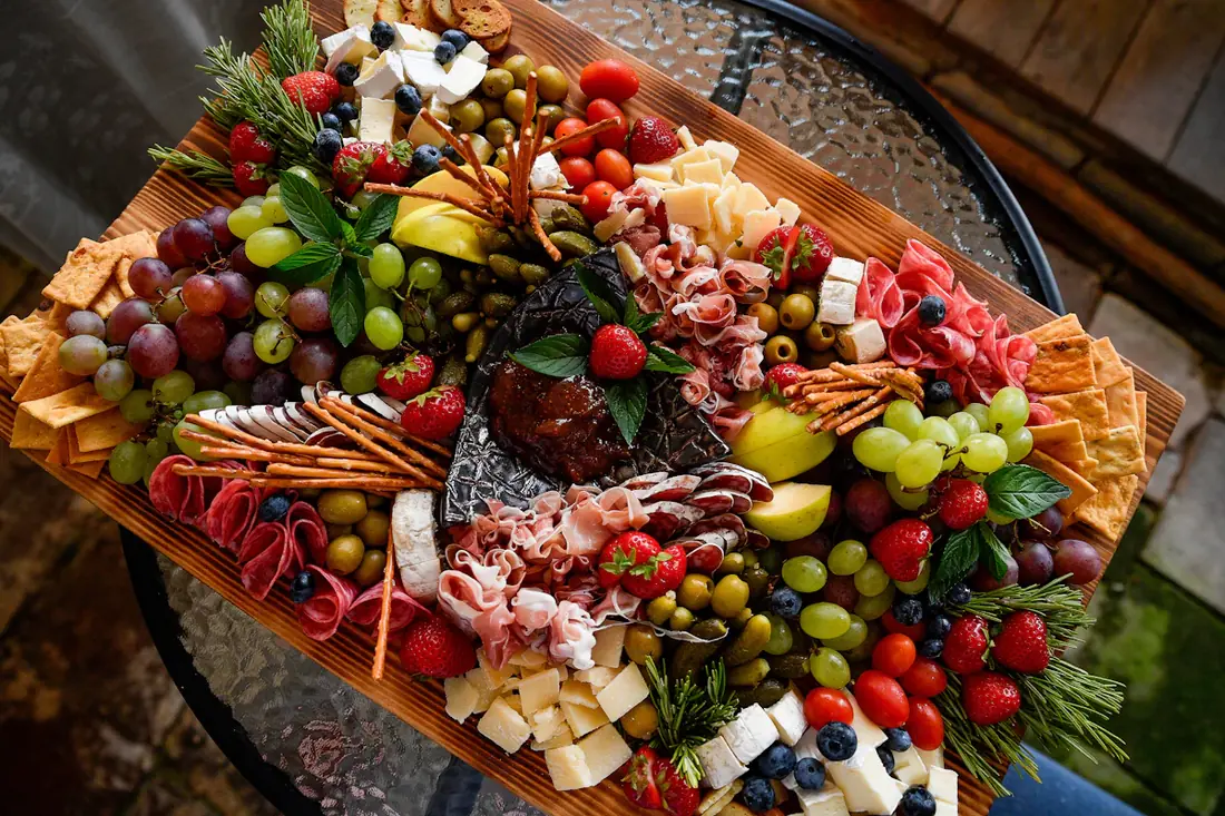 A large charcuterie board with fruit, cheese and cured meats