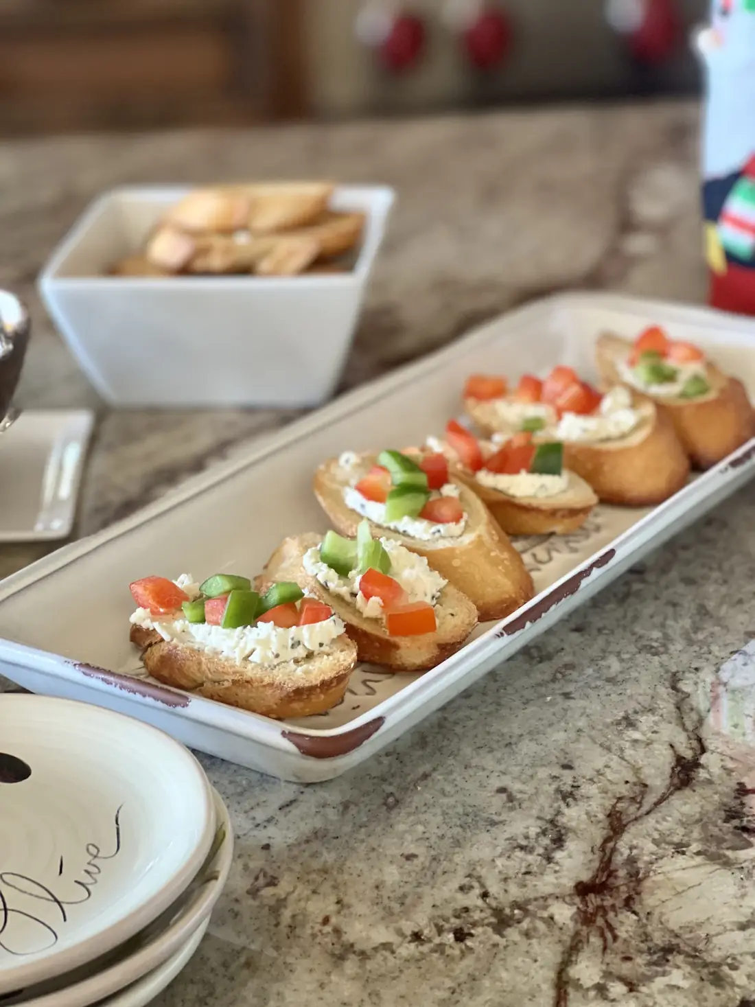 A tray of bruschetta with tomatoes and soft cheese