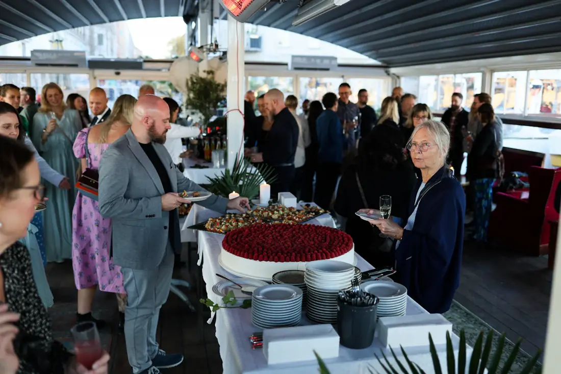 A crowd gathered around a catered table at a company party